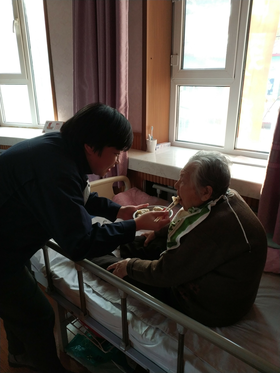 学院团委刘宇阳书记喂行动不便的老人吃饺子.png